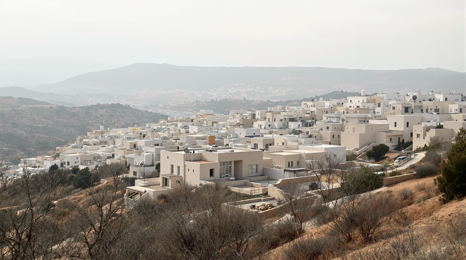 Illustration of a limestone hillside town in the central highlands seen from a distant ridge under soft overcast morning light.