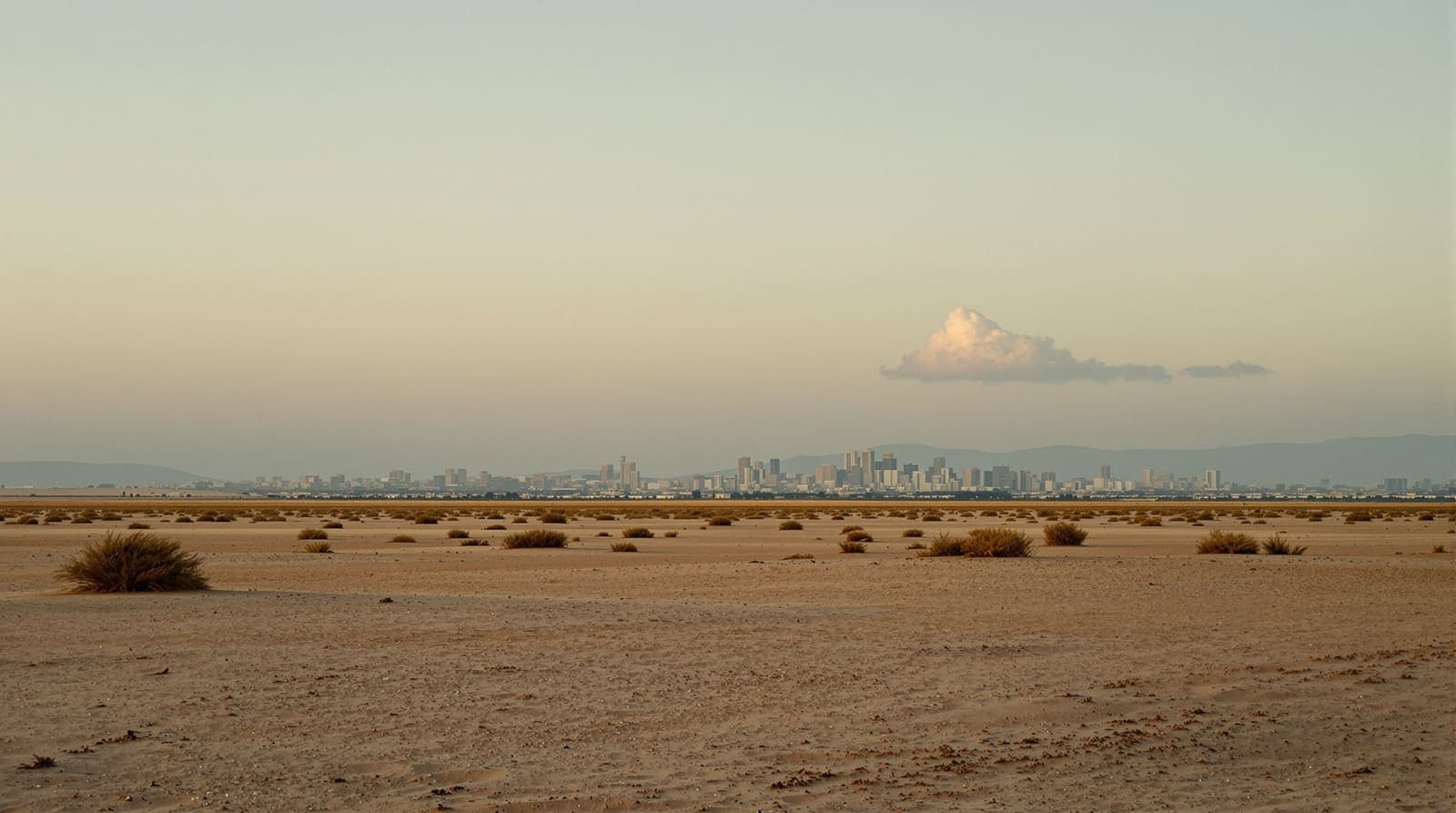 Illustration of a distant hazed southern Gaza skyline seen across flat open scrubland at dusk under a muted amber sky.