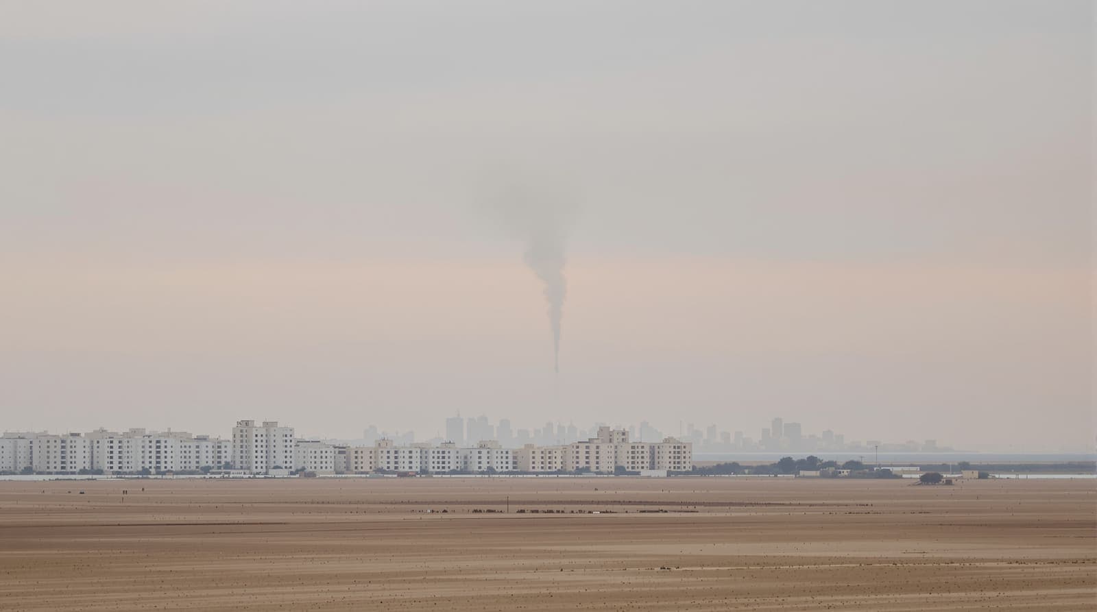 Illustration of the Gaza City skyline seen from a distance under a hazy dawn sky beside the Mediterranean coast