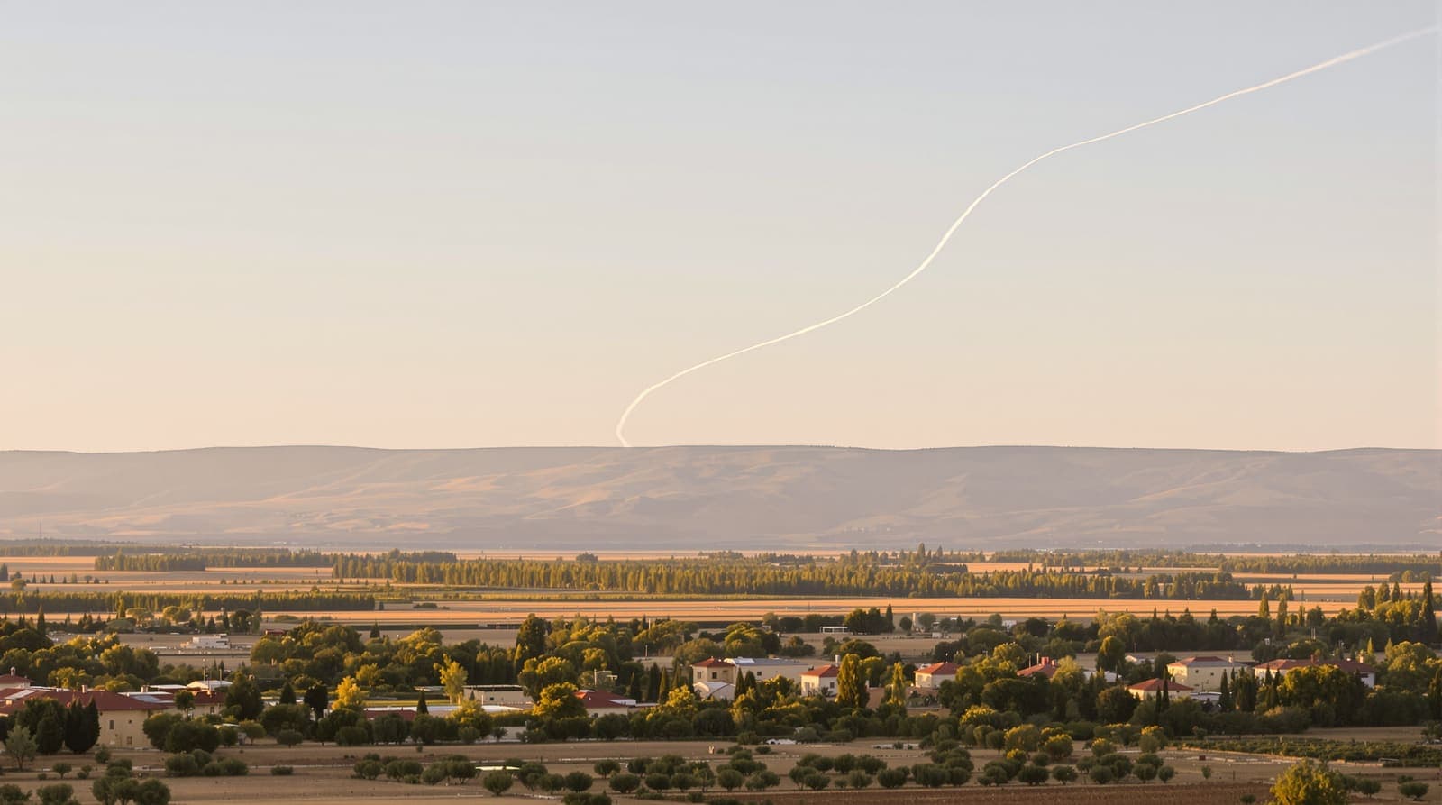 Illustration of a lone interceptor vapour trail curving across a pale dawn sky over the orchards and kibbutz rooftops of the Hula Valley.
