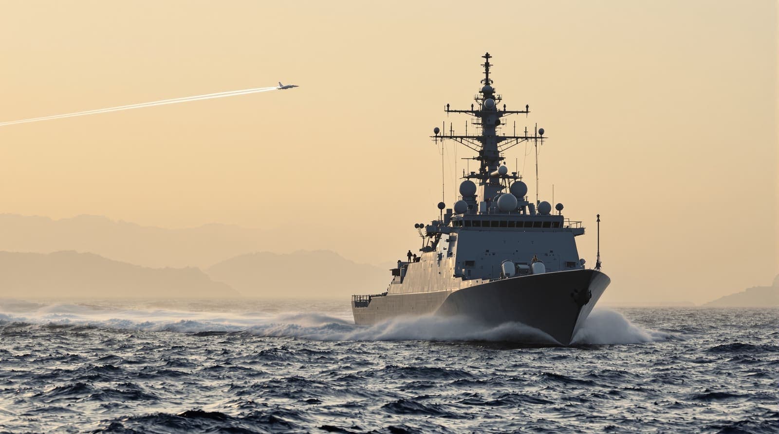 Illustration of a naval missile boat silhouetted nearly bow-on against a dawn sky, with a jet contrail high overhead.